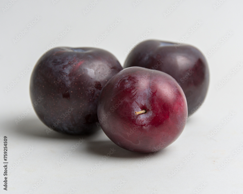juicy red plums on white background