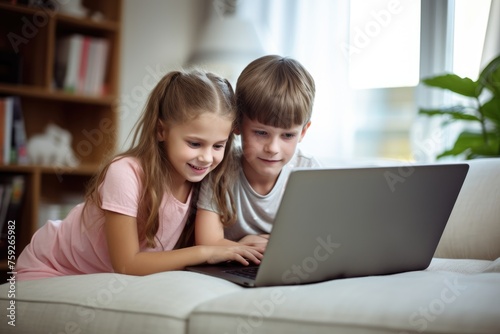 Focused boy and girl using a laptop together for education or entertainment indoors. Two Children Learning on Laptop © Anatolii
