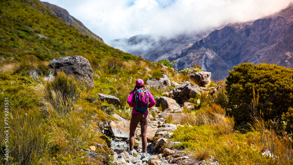 Fototapeta premium hiker girl enjoys a scenic path in southern alps - otira valley track in canterbury, new zealand south island, arthur's pass national park
