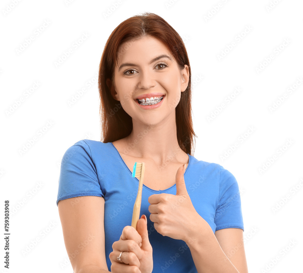 Young woman with dental braces and toothbrush showing thumb-up on white background Young woman with dental braces and toothbrush showing thumb-up on white background