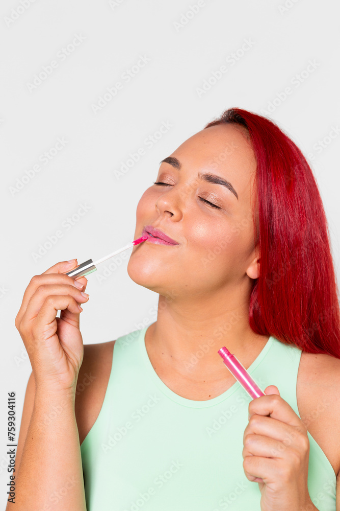 Vertical portrait of a young smiling girl applying lip gloss Vertical portrait of a young smiling girl applying lip gloss