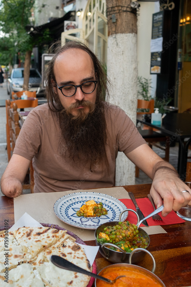 Male eating butter curry chicken at restaurant 