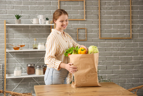 Young woman with paper bag ...