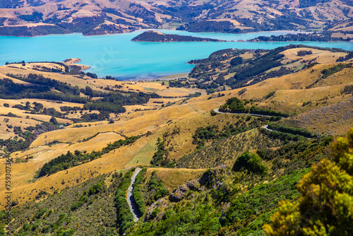 panorama of banks peninsula with winding road on a hill near akaroa harbour; canterbury, new zealand south island photo