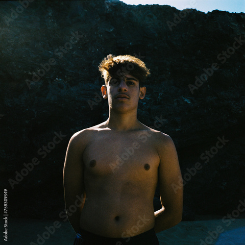 Beach Vibes: Shirtless Young Man on the Shore photo