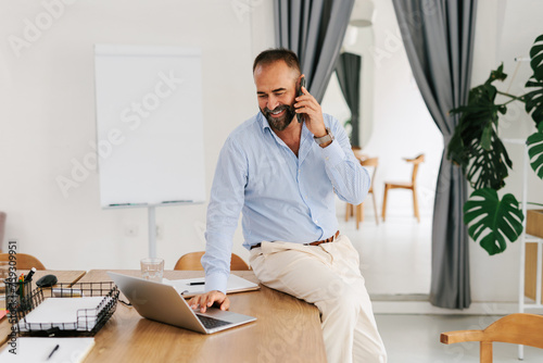 Portrait of adult businessman using smartphone in office  photo
