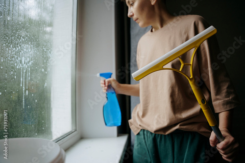 A woman washes a window in a room photo