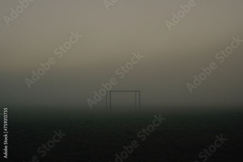 Lonely football goal standing in a foggy field. photo