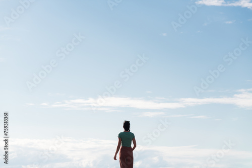 Standing woman looking at luminous blue sky photo