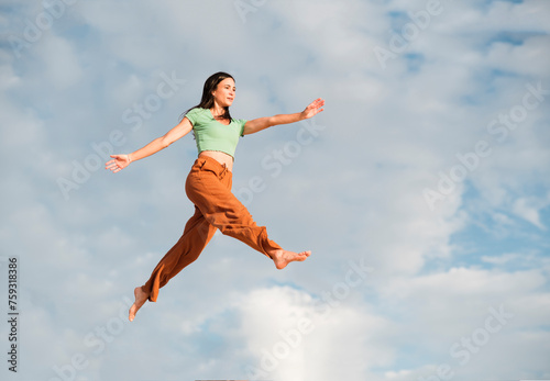 Dreamy portrait of woman daring to jump in the air photo