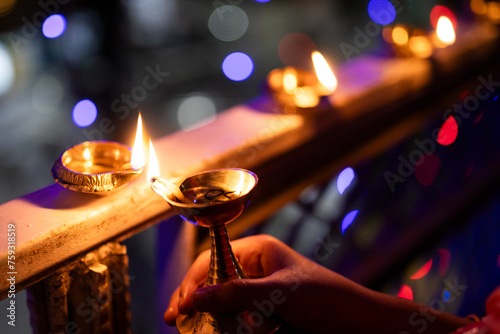 Little girl igniting oil lamps during diwali photo