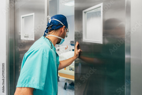 Male doctor entering in operating room for surgery at clinic photo