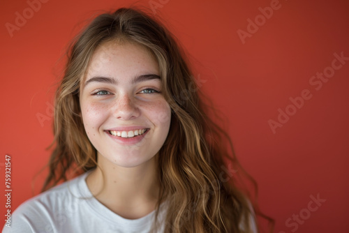 A young woman with long hair and freckles smiles for the camera
