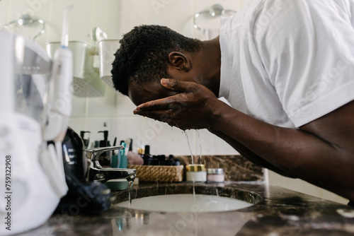 A man washing his face in the sink photo