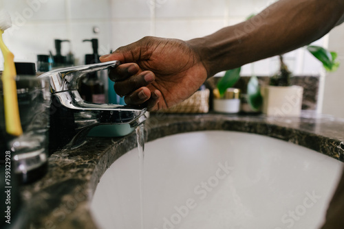 A person lifting up the tap water handle  photo