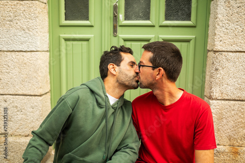 portrait of gay couple sitting at the door of house photo