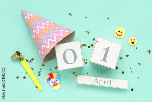 Calendar with party decor on turquoise background. April Fools Day celebration