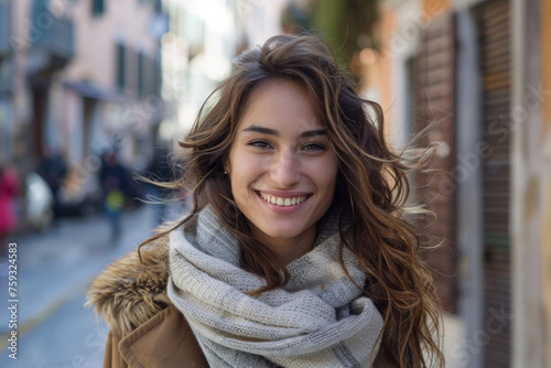 A woman wearing a scarf around her neck smiles for the camera