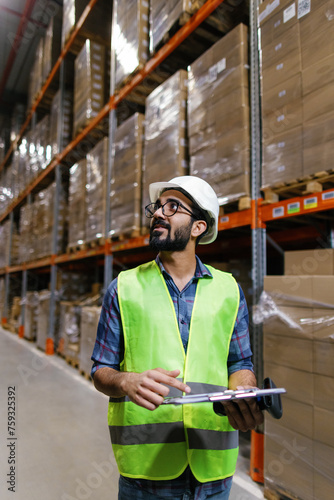 Foreign worker documenting warehouse operations storage photo
