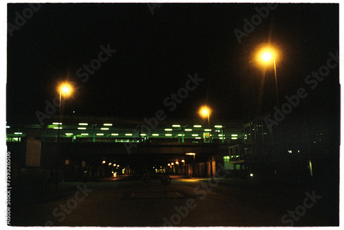 Metro station pedestrian bridge and its green city lights at night photo