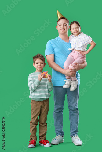Father and his little children with paper fish on green background. April Fool's Day celebration © Pixel-Shot