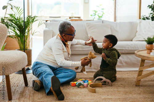 Grandmother and grandson playing with toys at home photo