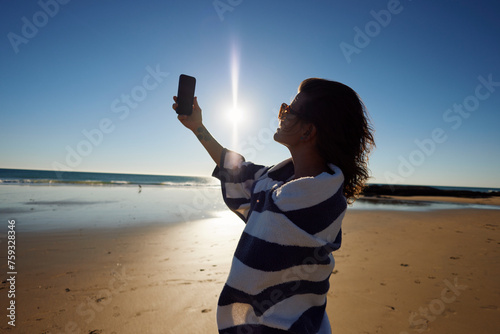 Woman captures a selfie on the shore photo