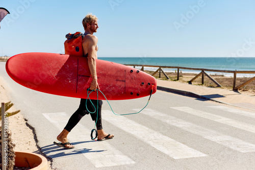 Surfer crosses the street photo