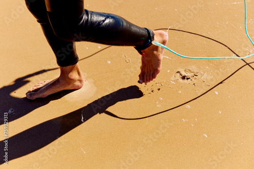 Surfer walks in the sand photo