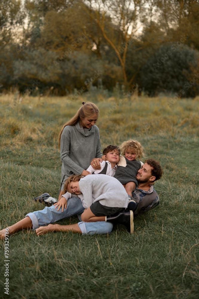 young parents playing with their children autdoors young parents playing with their children autdoors