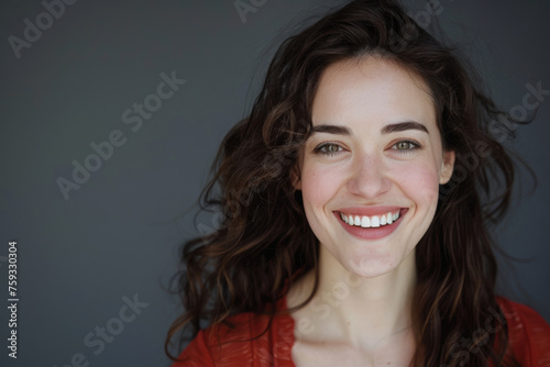 A woman is smiling with her hair blowing in the wind