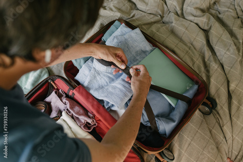 A man packing a suitcase on the bed photo