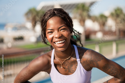 Cheerful black sportswoman laughing during workout photo