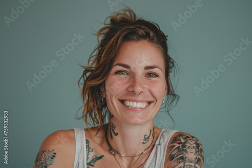 A woman with tattoos on her arms and neck smiles for the camera