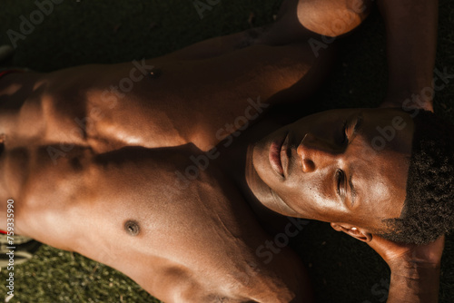 young man resting on the grass photo