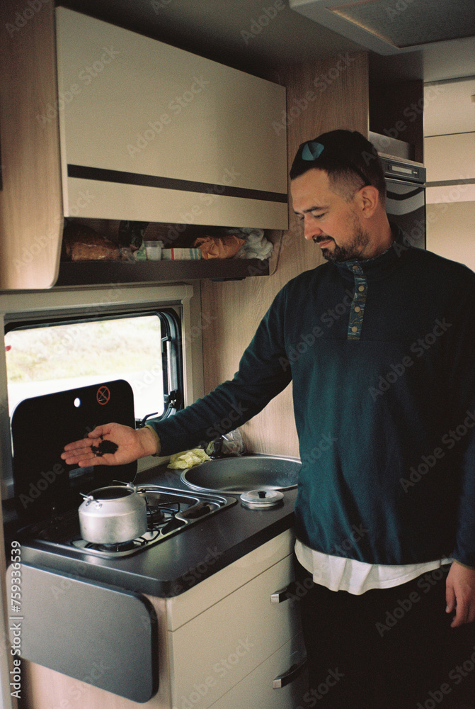 Man making tea in a campervan Man making tea in a campervan