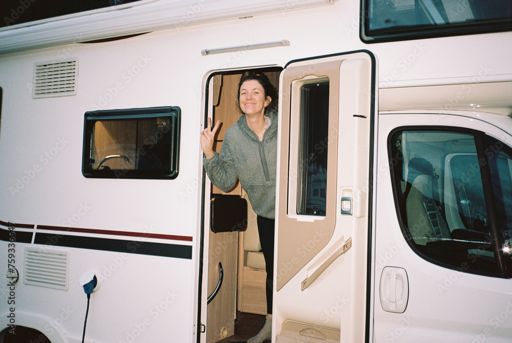 Smiling woman in campervan showing peace Smiling woman in campervan showing peace