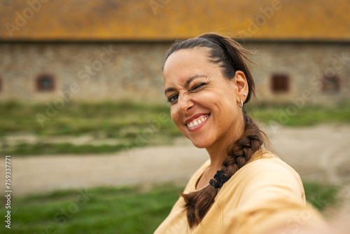 ugc of woman taking a selfie with her mobile phone outdoors photo