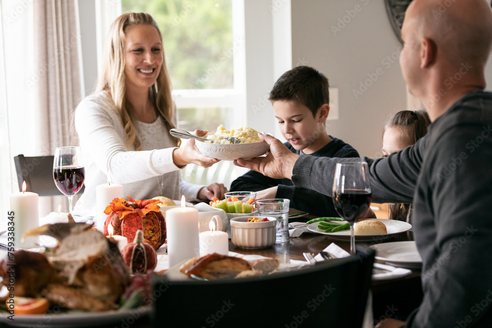Thanksgiving: Mother Passes Mashed Potatoes Across Table Thanksgiving: Mother Passes Mashed Potatoes Across Table