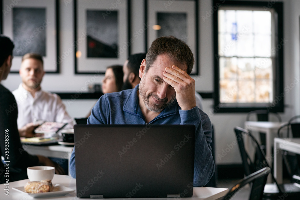 Business: Frustrated Man Working Alone In Coffee House