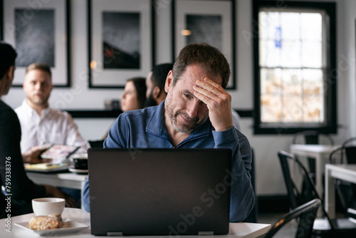 Business: Frustrated Man Working Alone In Coffee House photo