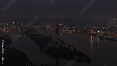 Aerial view of the TV/radio tower and the city by the river with evening lights photo