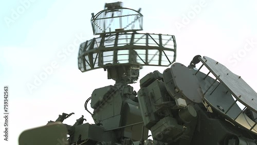 Military air defense radar. Anti missile defense system. Green military radar is rotating - control, surveillance and monitoring of the clear blue air. High tech technology in the army. photo