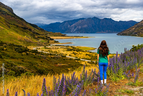 pretty girl enjoys the panorama of lake hawea near wanaka in otago, new zealand south island; 