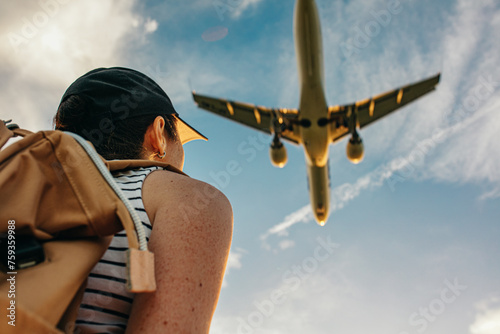 A traveler looks at a plane flying close