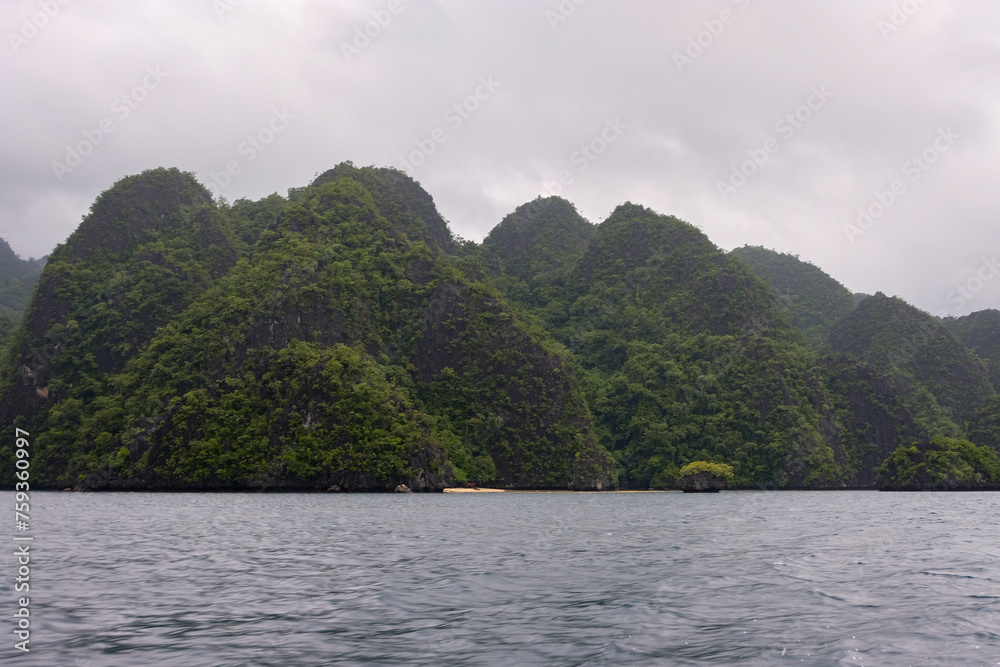 Scenic view of remote tropical islands nestled together on a wet, grey and overcast day during monsoon season in Palawan, Philippines