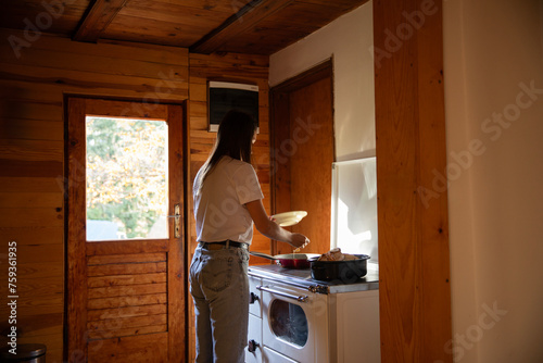 Woman cook breakfast at cabin photo