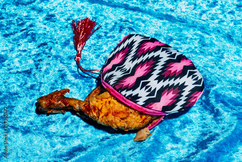 roasted chicken leg popping out of a multicolored purse photo