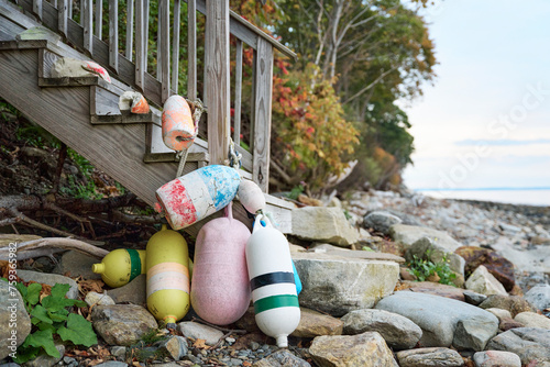 Colorful buoys tied up on a shoreline in coastal Maine photo