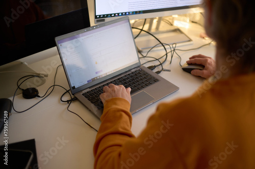 Woman working at home using multi screen set up on desk photo